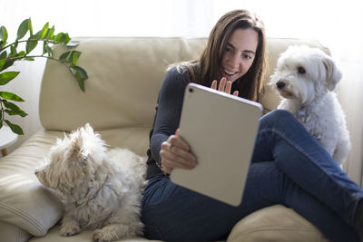 Young woman with dog sitting at home