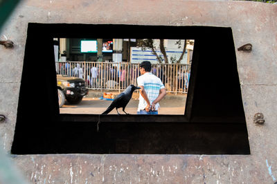 Full length of man sitting at window