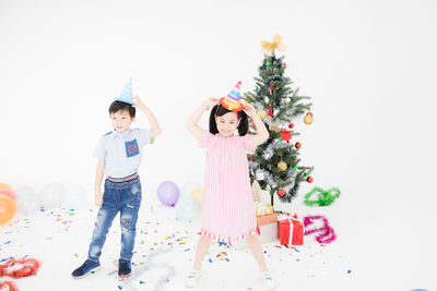 Full length of children standing in christmas tree