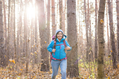 Full length of happy girl standing in forest