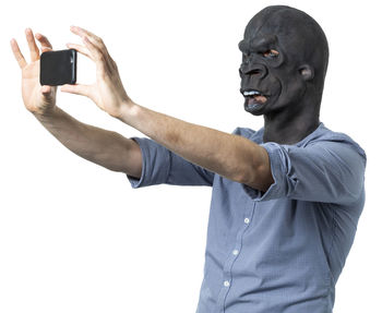 Midsection of man photographing against white background