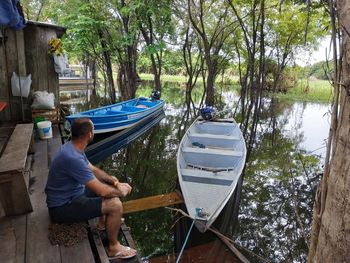 Man sitting on boat by lake