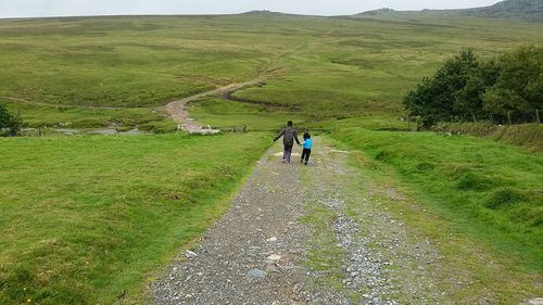 Full length of people walking on grassy field