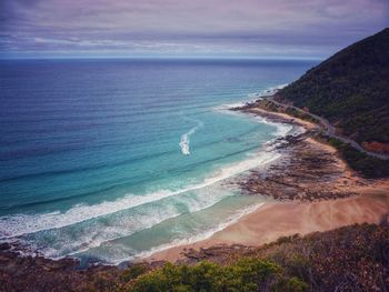 Scenic view of beach against cloudy sky