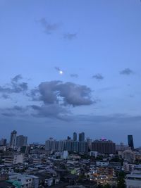 Buildings in city against sky at dusk