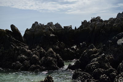 Scenic view of rock formation in sea against sky