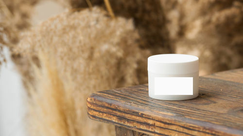 Mockup of a white jar of face and body skin cream on wooden tabletop. friendly product.