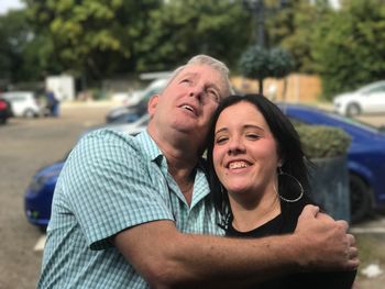 Portrait of daughter with father standing on field