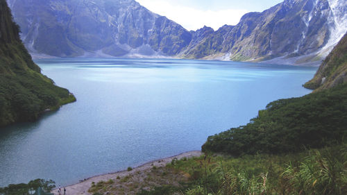 Scenic view of lake by mountains against sky