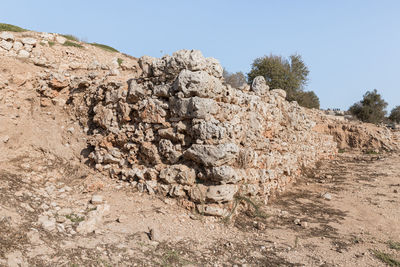 View of rocks on landscape against clear sky