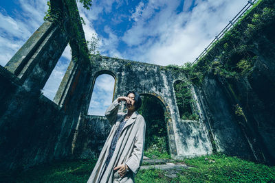 Low angle view of woman standing on bridge against sky