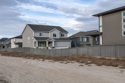 Houses by buildings against sky during winter