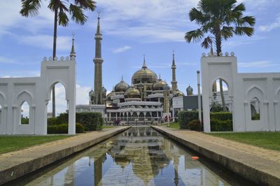 View of mosque and building against sky