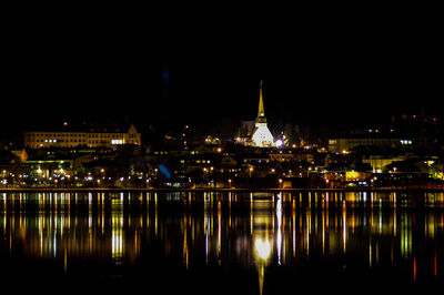 Illuminated bridge over river at night