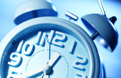 Close-up of clock over blue background