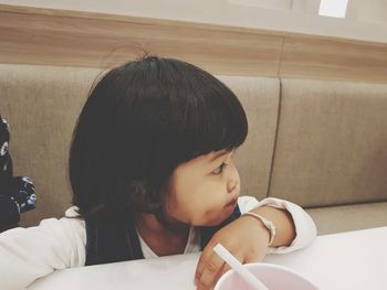 Baby girl looking away at restaurant