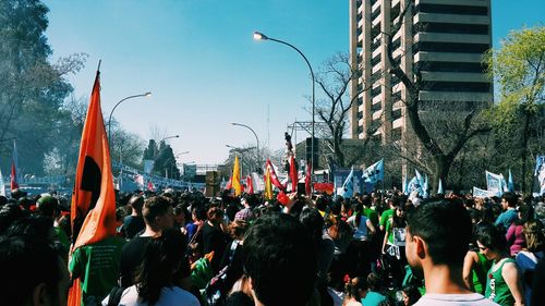 Crowd in city against sky