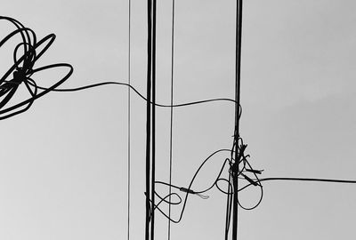 Low angle view of power lines against clear sky