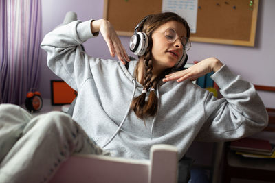 A brunette woman survives while listening to music on wireless headphones.