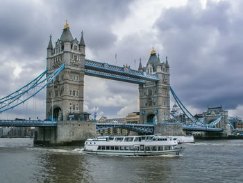 Bridge over river against cloudy sky