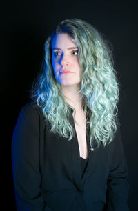 Portrait of a beautiful young woman over black background