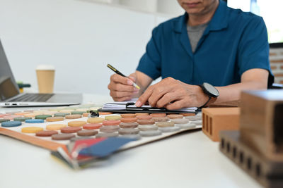 Midsection of businessman working on table
