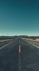 Road passing through landscape against clear sky