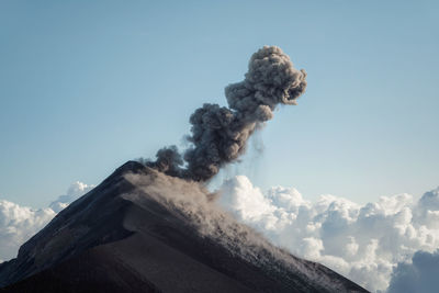 View of smoke emitting from volcanic mountain against sky