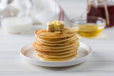 Honey sauce pours over a stack of pancakes. breakfast concept.