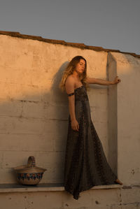 Portrait of woman standing against wall