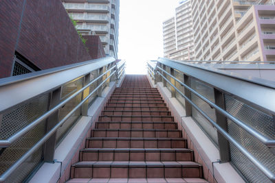 Low angle view of staircase amidst buildings in city