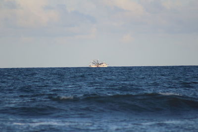 Boat sailing in sea against sky