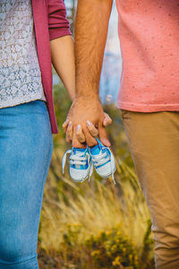 Low section of man and woman standing in grass