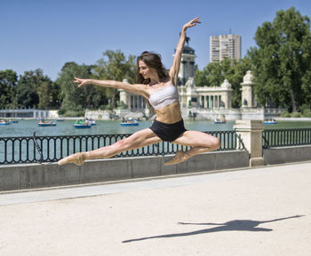 Full length of young woman exercising in park