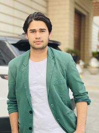 Portrait of young man standing in city