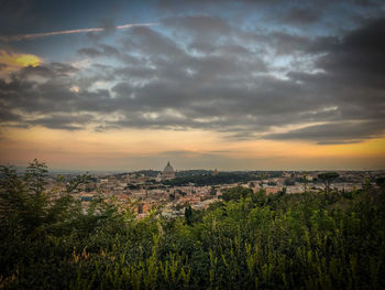 Aerial view of townscape against cloudy sky during sunset