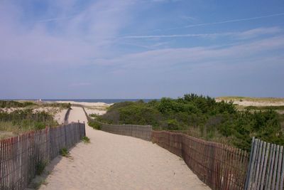 Footpath on beach against sky