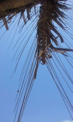 Low angle view of electricity pylon against clear blue sky