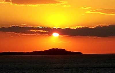 Scenic view of silhouette landscape against orange sky