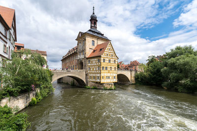 Arch bridge over river against buildings