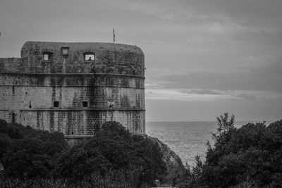 Building by sea against sky