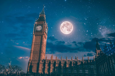 Low angle view of clock tower against sky at night