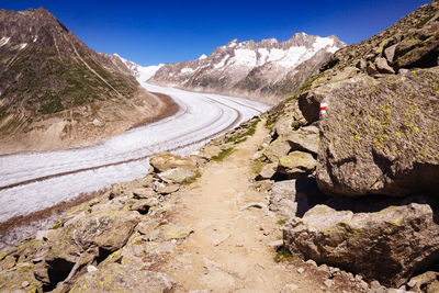 Scenic view of road by mountains against sky