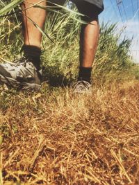 Low section of man standing on field