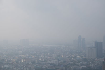 Aerial view of buildings in city against sky