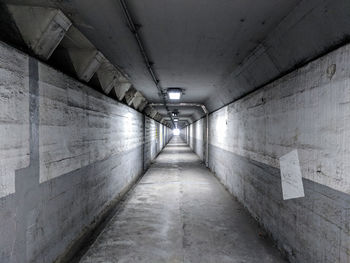 Empty pedestrian tunnel with concrete walls.