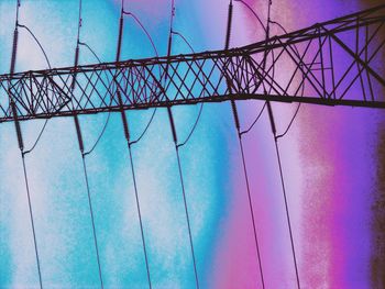 Low angle view of electricity pylon against blue sky