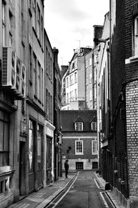 Road amidst buildings in city against sky