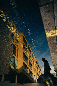 Low angle view of man walking on street at night