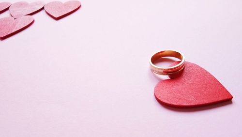 Close-up of heart shape over pink background